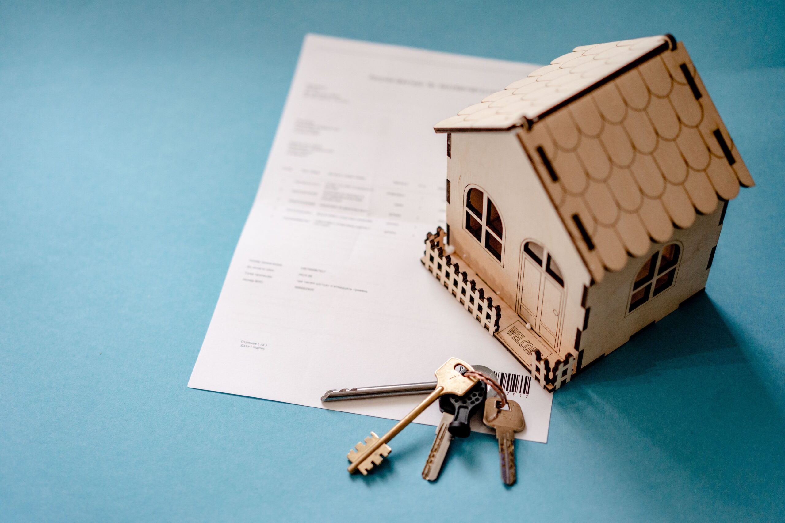Wooden house with keys and contract